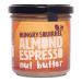 The photo shows six 180g jars of Hungry Squirrel Almond Espresso breakfast spread arranged in two rows on a neutral surface. Dark brown lids and cream labels display almond and espresso-bean artwork; warm light reveals glossy, rich-brown spread and scattered almonds.