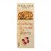 Golden-brown rectangular toast biscuits lie stacked with several loose pieces nearby; each slice shows scattered ruby cranberries and dark raisins embedded in a grainy, crumbly texture. A light dusting of sugar, warm tones and soft shadowing evoke a rustic bakery scene. Soft highlights rim the fruit