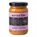 Six 285g jars of Butter Bike Co Almost Smooth peanut butter sit in a neat cluster, amber contents visible through clear glass. Creamy-spread labels feature a bicycle logo and bold type. Light reflects off metal lids and smooth surfaces, casting soft shadows.