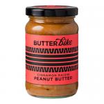 Six jars of Butter Bike Co Cinnamon Raisin peanut butter sit grouped in two neat rows, their clear containers revealing a speckled, cinnamon-brown spread. Each jar sports a matching label with logo and product name; light falls softly on the textured surface and simple white background. and shadows.