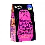 A rectangular retail box of twelve 57g packets sits front-facing. Bright red-orange packaging displays the Boom Kitchen logo and bold 'Tikka Tarka Masala' text, a glossy photo of a spiced curry bowl, scattered spice illustrations, and small informational text blocks.