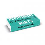 A small mint-green metal tin sits open to reveal a neat row of smooth white round mints. The lid displays bold white Peppersmith lettering and a stylized peppermint leaf on a turquoise background. Soft studio lighting casts subtle highlights and shallow reflections. A faint shadow sits under the tin.