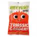 Bright green pouch shows the HEY YUM! logo and whimsical dinosaur illustrations among ferns and flowers. A small clear window reveals assorted organic fruit gummies in leaf and dinosaur shapes. Clean white typography names Triassic Garden and displays the 100g weight on a neutral background. Soft-lit