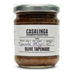 A clear glass jar reveals dark, chunky olive tapenade. The jar features a green-and-white label with the CASALINGA brand name in bold, product text and small icons. A silver screw lid seals the jar; flecks of herbs and oil glisten in the spread.