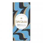 A small 20g dark chocolate bar sits against a white background. Matte black wrapper shows the Love Cocoa logo in gold, minimalist typography and an image of Maldon sea salt flakes. Beside it, glossy dark chocolate squares display coarse salt crystals.