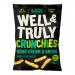 Bright green and white multipack sits against a plain background, displaying the Well&Truly logo and bold 'Crunchy Sour Cream & Onion Sticks' text. A pile of golden, ridged snack sticks and a small bowl of pale sour cream with chopped chives appear beside scattered herb flecks. Pack shows ten sticks