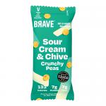A bright multipack of twelve compact snack bags sits against a neutral backdrop. Each 35g packet displays the Brave logo, green and cream color blocks, and vivid illustrations of peas, sour cream dollop and chive sprigs. Scattered roasted peas and crisp typography finish the front art. Bold serving image.