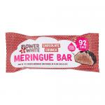 A neat row of twelve meringue bars sits on a white surface. Each pale, crisp meringue is coated in glossy white chocolate, sprinkled with crunchy chocolate pieces and adorned with small floral sugar decorations and pastel petals. Light crumbs scatter around the clean presentation. Soft shadows fall.