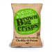 A group of brown kraft-style bags with the Brown Bag Crisps logo and Cheddar & Onion flavor label sits on a plain surface. Orange and green accents surround a cheese wedge and spring onion illustration; a few golden ridged crisps spill from an open pack.