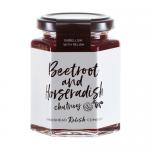 Six glass jars of Hawkshead Relish Beetroot & Horseradish Chutney stand grouped on a pale surface. Deep ruby contents show flecks of beetroot. Cream labels with crisp black type and a small round logo wrap each jar; reflective golden lids and light reflections add depth. Soft warm highlights shimmer.