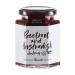 Six glass jars of Hawkshead Relish Beetroot & Horseradish Chutney stand grouped on a pale surface. Deep ruby contents show flecks of beetroot. Cream labels with crisp black type and a small round logo wrap each jar; reflective golden lids and light reflections add depth. Soft warm highlights shimmer.