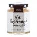 Six clear glass bottles of Hawkshead Relish Hot Horseradish Sauce sit on a white surface. The creamy pale sauce shows through red-and-white labels with the brand name; black caps and soft studio lighting cast gentle shadows.