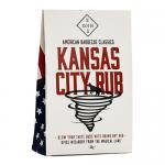 Six identical 60g glass jars sit in two neat rows, each topped with a black lid and labeled 'Bohn's Kansas City Rub'. Labels show bold red and cream graphics; the rub inside appears coarse and reddish-brown. The jars rest on a plain white surface with soft studio lighting. Soft shadows gently drape.