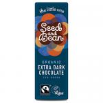 A compact, rectangular dark chocolate mini bar shows a glossy, deep-brown surface divided into small squares. Its top is dotted with a scattering of mixed seeds and tiny pale flecks. The bar sits against a neutral background, highlighting its smooth edges and rich color.