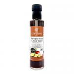 A clear glass bottle holds glossy amber-orange stir-fry sauce. A white label wraps the middle with bold brand lettering and smaller Thai-style product text. Simple tropical illustrations and subtle green accents frame the label. Light reflects off the smooth, syrupy surface. Crisp, modern label art