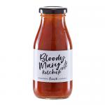 Six glass bottles of Hawkshead Relish Bloody Mary Ketchup stand on a wooden board, deep red sauce visible through clear glass. White labels show bold black and red text and a small logo. Soft natural light creates gentle highlights and subtle shadows.