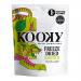 Bright yellow-and-green boxes and slim single-serve pouches sit in a neat row, each pouch showing a vivid jackfruit illustration and a clear 12g label. Pale, porous jackfruit pieces peek through a small window; irregular, crisp fragments and scattered seeds create visual texture. warm highlights glow