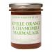 Six clear glass jars sit in neat rows, each filled with glossy amber-orange marmalade. Cream labels read 'London Borough of Jam' with botanical chamomile artwork and vintage typography. Metal lids catch light; citrus peel flecks and translucent gel texture show through the glass. Soft warm shadows..