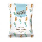 Photo shows a neat display of Dreamers Sweet & Salty Popcorn 40g packets stacked in a 24-pack box. Bright yellow and teal packaging features the Dreamers logo, playful popcorn illustrations, clear 40g label, and an open packet revealing glossy, lightly caramelised popcorn kernels. A soft steam rises