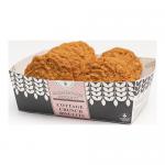 A dozen farmhouse biscuits sit stacked on a rustic wooden board, their golden-brown crusts glinting with coarse sugar. Flaky layers and craggy edges reveal a tender interior. A linen napkin and scattered crumbs frame the scene under soft, warm bakery light. Nearby jar and flour dusting add textures.