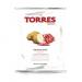 A glossy bag of Torres Iberian Ham crisps sits upright against a plain background. The packaging shows deep red fading to cream, a photo of thin wavy crisps beside sliced Iberian ham, gold lettering and a small green emblem, with crisp nutritional text along the bottom. A subtle sheen on the wrapper