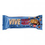 Photo shows a 12-pack box of Vive Natural Crunchy Hazelnut protein bars. Earthy brown and cream wrappers display the green Vive logo, hazelnut illustrations and a cross-section of a bar revealing a dense, nutty, crunchy interior. All items sit on a plain white background.