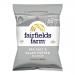 Fairfields Farm Salt & Black Pepper crisps pack sits on a plain surface, the 40g label and branded logo prominent. The bag shows salt crystals and whole black peppercorn imagery; several golden potato crisps spill from a torn top beside scattered seasoning.