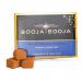 A compact rectangular box of Booja-Booja Around Midnight Espresso truffles sits on a neutral surface. The dark navy packaging displays the Booja-Booja logo and elegant typography, alongside a glossy dark chocolate truffle and subtle coffee bean accents. Soft highlights trace the textured finish, softly.