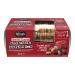 A clear plastic pack displays golden-brown rectangular seeded toasts studded with glossy dried cranberries and green pumpkin seeds. Each slice shows a rustic, grain-speckled texture. A simple bakery sleeve with green accents labels the stacked loaves.