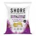 A glossy pouch of Shore Seaweed Chips sits against a neutral background. Emerald-green seaweed crisps with curled, textured edges spill beside the packet. Packaging shows ocean-blue graphics, Asian-style red and gold accents and bold brand lettering.