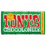 The image shows fifteen Tony's Chocolonely milk chocolate hazelnut bars in 180g packs, their bold, colorful wrappers and large white logo dominating the frame. Several bars are stacked and a few are opened to reveal glossy milk chocolate with visible hazelnut pieces on a neutral background. Closeup.