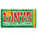 The image shows fifteen Tony's Chocolonely milk chocolate hazelnut bars in 180g packs, their bold, colorful wrappers and large white logo dominating the frame. Several bars are stacked and a few are opened to reveal glossy milk chocolate with visible hazelnut pieces on a neutral background. Closeup.