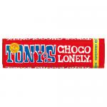 A bright, glossy wrapper displays the bold Tony's Chocolonely logo across its center. A stylized milk chocolate bar with uneven, chunky segments appears alongside handwritten-style flavor text and graphic accents. The packaging rests flat on a neutral, lightly textured background with soft shadows.