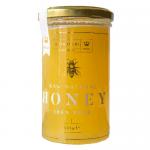 Six clear glass jars of golden honey sit clustered on a neutral surface. Each 325g jar displays a white label reading Maters & Co Raw Cambridgeshire Spring Honey and a metal lid. Warm light highlights viscous amber tones, subtle air bubbles and natural texture under soft reflections. Soft shadows...