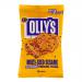 A neat stack of thin, golden-brown pretzels sits beside an open multiseed packet, seeds of sesame, flax and sunflower clinging to the crisp surface. The packet shows bright branding and a small window; scattered crumbs and seeds create a textured still-life on a pale backdrop. Soft light falls warm.
