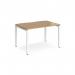 The photograph captures a sleek and modern Dams Bench Desking Adapt single desk. It features a white frame and an oak top, measuring 1200mm x 800mm. The clean design exudes a professional and minimalist aesthetic.