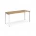 The picture shows a Dams Bench Desking Adapt single desk measuring 1600mm x 600mm, with a white frame and oak top. The desk has a sleek and modern design, with clean lines and a durable surface for working. It is a versatile and practical addition to any office space.