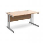 The photograph shows a sleek and modern desk with a silver cantilever frame and a beech wood top measuring 1400mm by 800mm. The desk has a clean and professional appearance, making it suitable for any office or workspace. Its simple design allows for easy customization and organization.