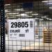 This image shows a durable sign with clear A4 pockets hanging from wire, ideal for organizing and displaying important documents in a warehouse setting. The sleek and sturdy design can withstand daily use and ensures documents stay secure.