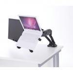 In the picture, a sleek black laptop cradle sits on a desk with various laptop accessories scattered around it. The laptop is tilted upwards, supported by the adjustable cradle. Cords and a mouse can be seen connected to the laptop. The dark color and modern design give the cradle a dynamic and professional appearance.