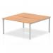 This image features an Evolve Plus 1600mm B2B bench desk with an oak top and silver frame, designed for 2 people to use in an office setting. The dynamic design encourages collaboration and efficient use of space.