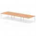The photograph captures a sleek and modern office space featuring a versatile Dynamic Bench Desking Evolve Plus 1600mm B2B 6 Person Bench Desk. With a striking oak top and clean white frame, this desk is perfect for collaborative work with its open and dynamic design.