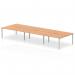 The photo shows a sleek and modern office space with the Dynamic Bench Desking Evolve Plus 1600mm B2B 6 Person Office Bench Desk as its focal point. The surface is made of oak, giving a natural and warm touch, while the frame is silver, adding a touch of sophistication. The desk is designed to accommodate up to 6 people, making it perfect for collaborative work.