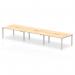 The photo showcases a sleek and modern dynamic bench desk, featuring a stunning maple top and a silver frame. With enough space to comfortably accommodate 6 people, this office bench desk is perfect for collaborative work environments.