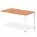 This photo features a modern and sleek Dynamic Bench Desking Evolve Plus 1400mm Single Row Office Bench Desk Extension Kit with an oak top and white frame. The desk is spacious and functional, perfect for any office setting.