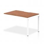 This picture features a sleek and modern office bench desk, measuring 1200mm, with a stylish walnut top and a clean white frame. This dynamic bench desking set exudes a professional and efficient vibe, perfect for any modern workspace.
