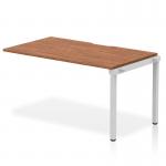 This photo features a sleek and modern Dynamic Bench Desking Evolve Plus desk, measuring 1400mm in length and constructed with a walnut top and silver frame. The single row design provides ample workspace, perfect for any office environment.