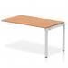 This image features a sleek and modern Dynamic Bench Desking Evolve Plus 1400mm single row office bench desk extension kit in oak top and silver frame. The desk is in a clean and open layout, perfect for collaborative work environments.