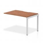 This photograph features a sleek and modern Dynamic Bench Desking Evolve Plus 1200mm Single Row Office Bench Desk Ext Kit in walnut with a silver frame. The streamlined design and premium materials give off a professional and stylish vibe, making it perfect for any office space.