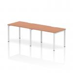 This photograph features a modern, versatile office setup with the Dynamic Bench Desking Evolve Plus 1200mm desk. The sleek beech top is complemented by a white frame, creating a clean and professional look. With room for two people, this desk is perfect for collaborating and maximizing productivity.